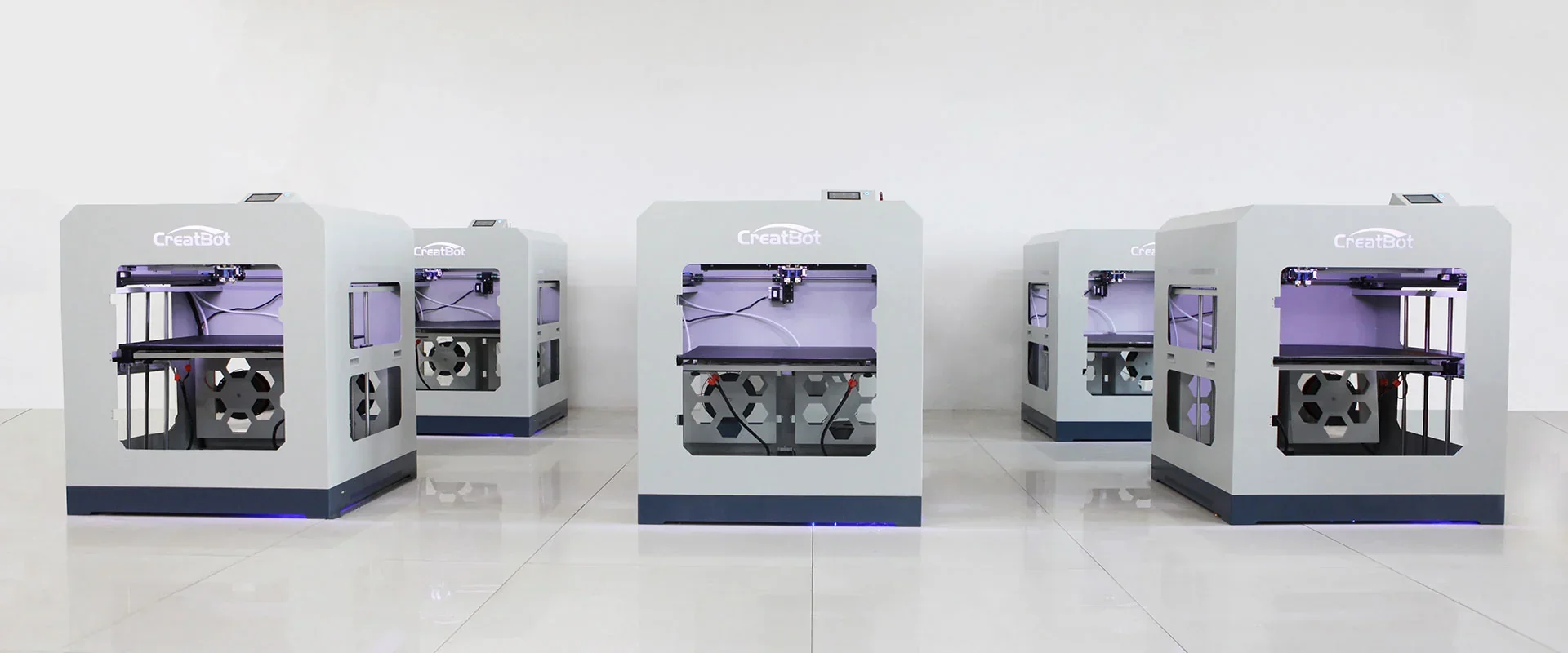 Creatbot D600 Pro 3D printers in a clean, white room, showcasing multiple units with visible branding and illuminated interiors.