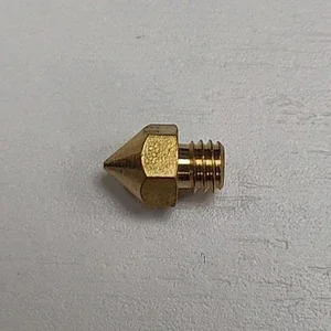 Brass nozzle for Creatbot D600 Pro 3D printer, showcasing its thread and tip on a light surface.