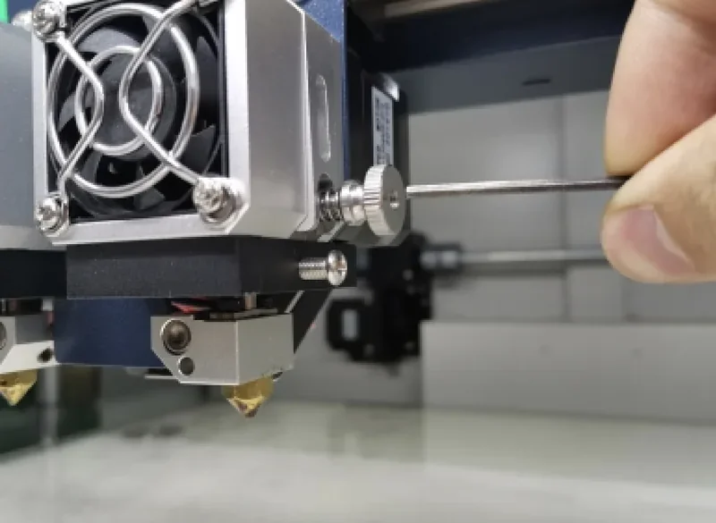 CreatBot D600 Pro 3D printer nozzle assembly being adjusted with a tool in a well-lit workspace.