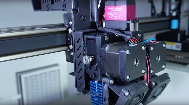 Creatbot D600 Pro2 HS 3D printer nozzle assembly shown in close-up with wires and cooling fans in a workshop setting.
