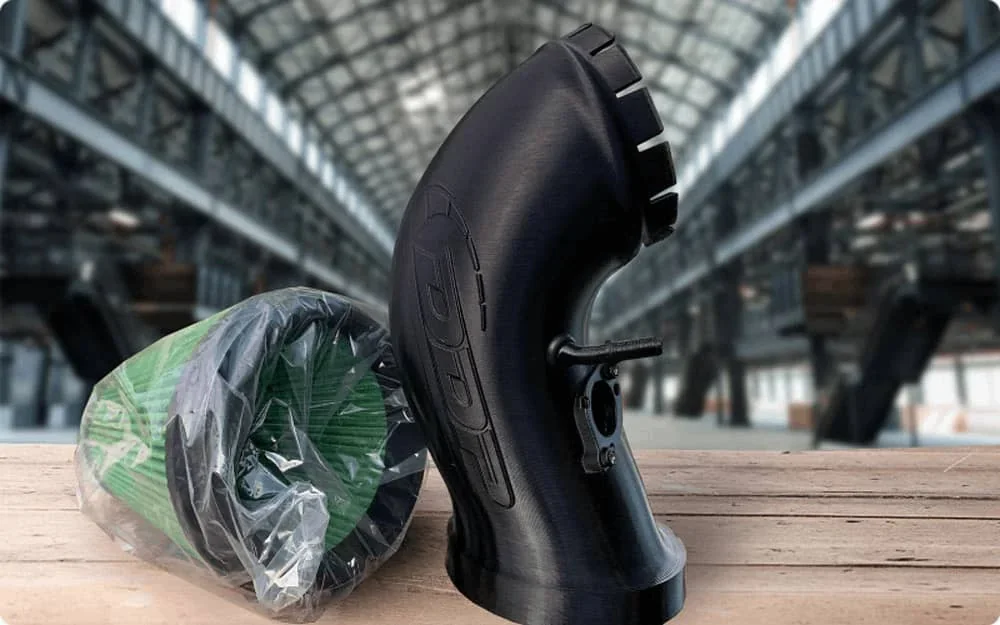 Creatbot D600 Pro2 HS printed black pipe and a green filter in an industrial setting on a wooden table.