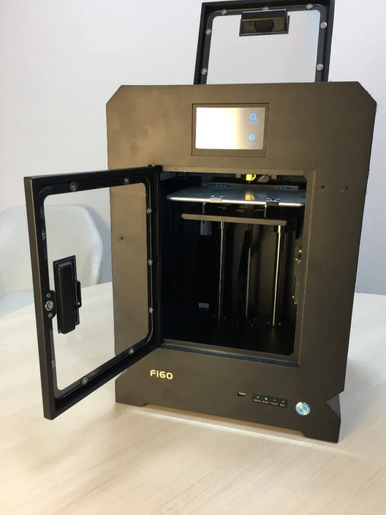 Creatbot F160 3D printer with open door, showcasing its interior and control interface on the front, set on a light-colored table.