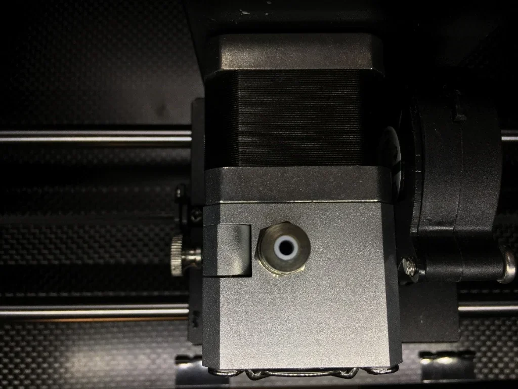 Creatbot F160 3D printer component, showing a detailed close-up of the print head assembly and extruder mechanism on a textured surface.