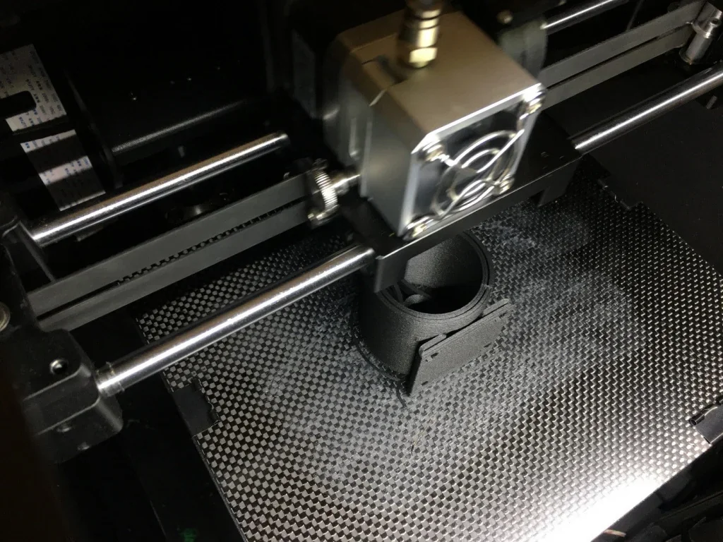 CreatBot F160 3D printer in action, printing a black cylindrical part on a textured build plate, showcasing precision and detail.