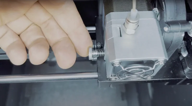 Hand adjusting component inside the Creatbot F160 3D printer, showcasing mechanical parts and detailed settings for precise printing operation.