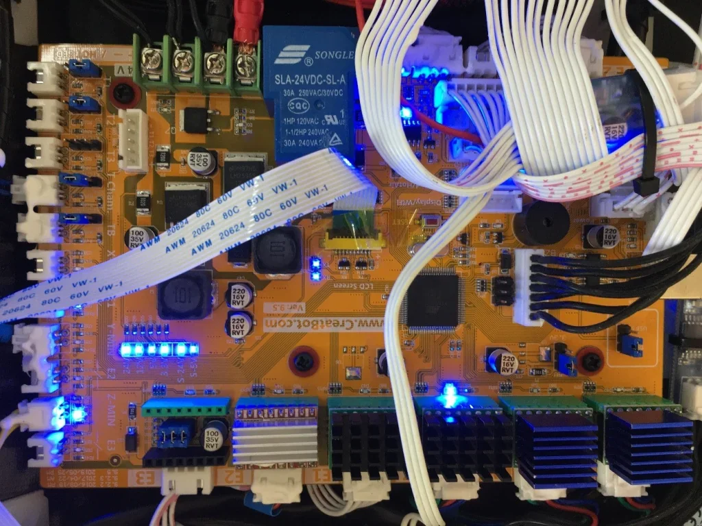 Creatbot F160 3D printer motherboard with blue LED lights, wires, and connectors. Visible branding on circuit board indicating model specifics.