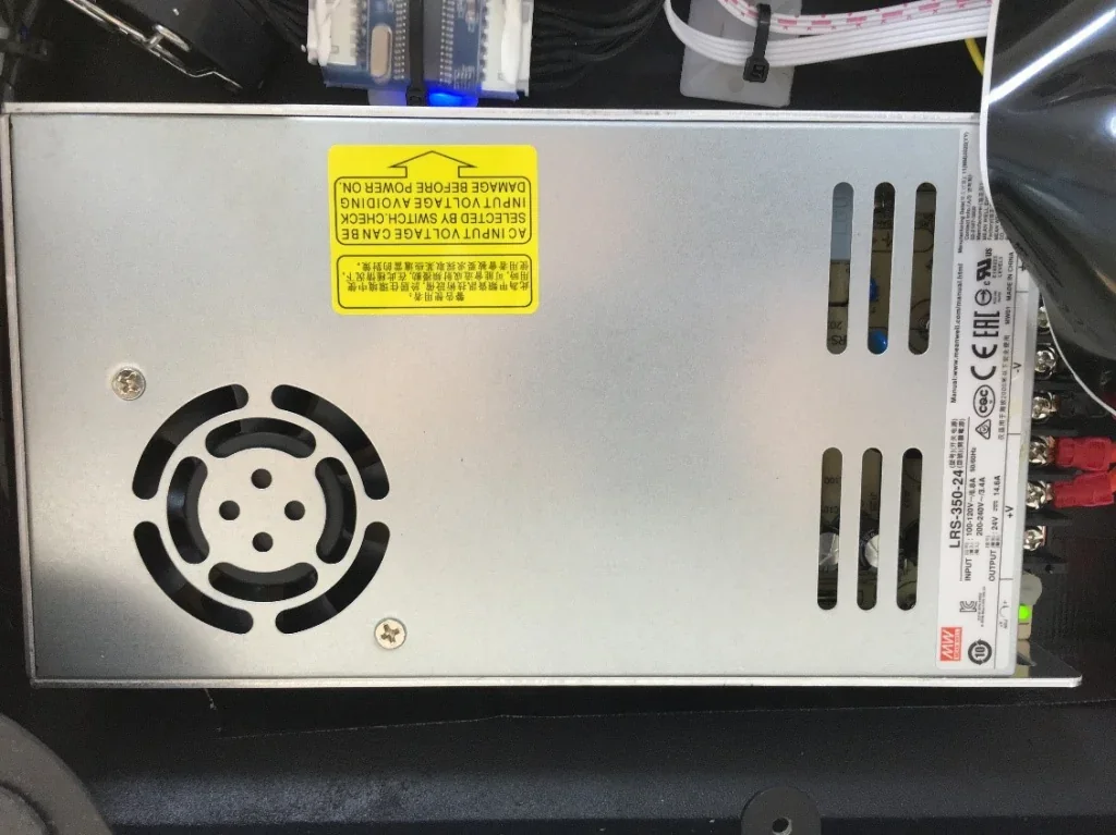 Creatbot F160 power supply with fan, vent slots, and warning label, showcasing internal components of the 3D printer in a detailed view.