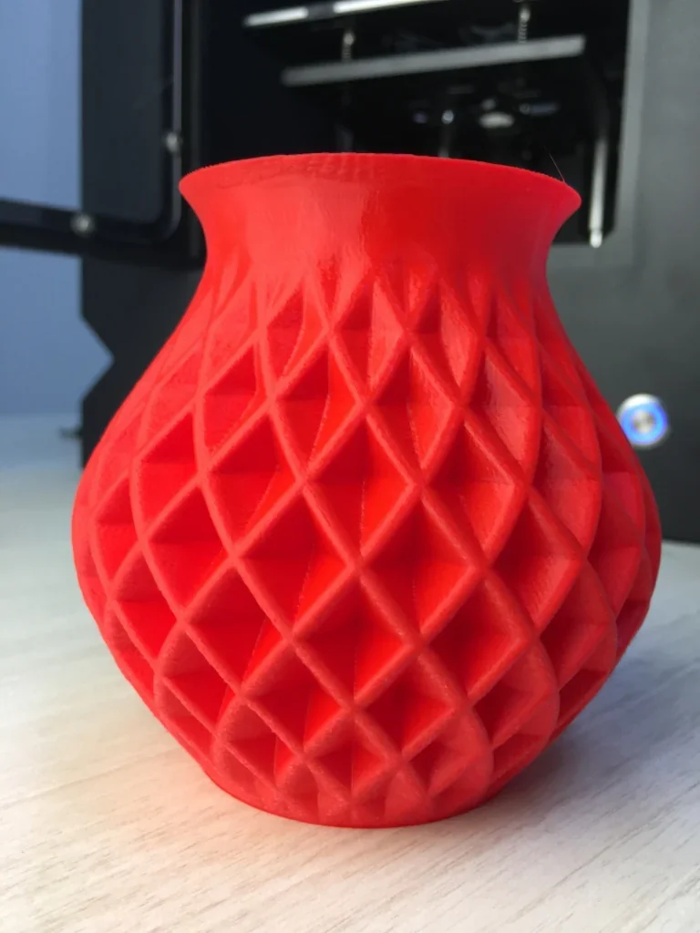 Red vase with a geometric pattern, 3D printed by Creatbot F160. The print features intricate diamond shapes, highlighting the printer’s precision.
