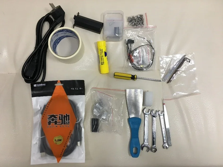 Creatbot F160 accessories on a beige surface, including screwdriver, tape, power cord, cables, spanner set, and packaging materials.