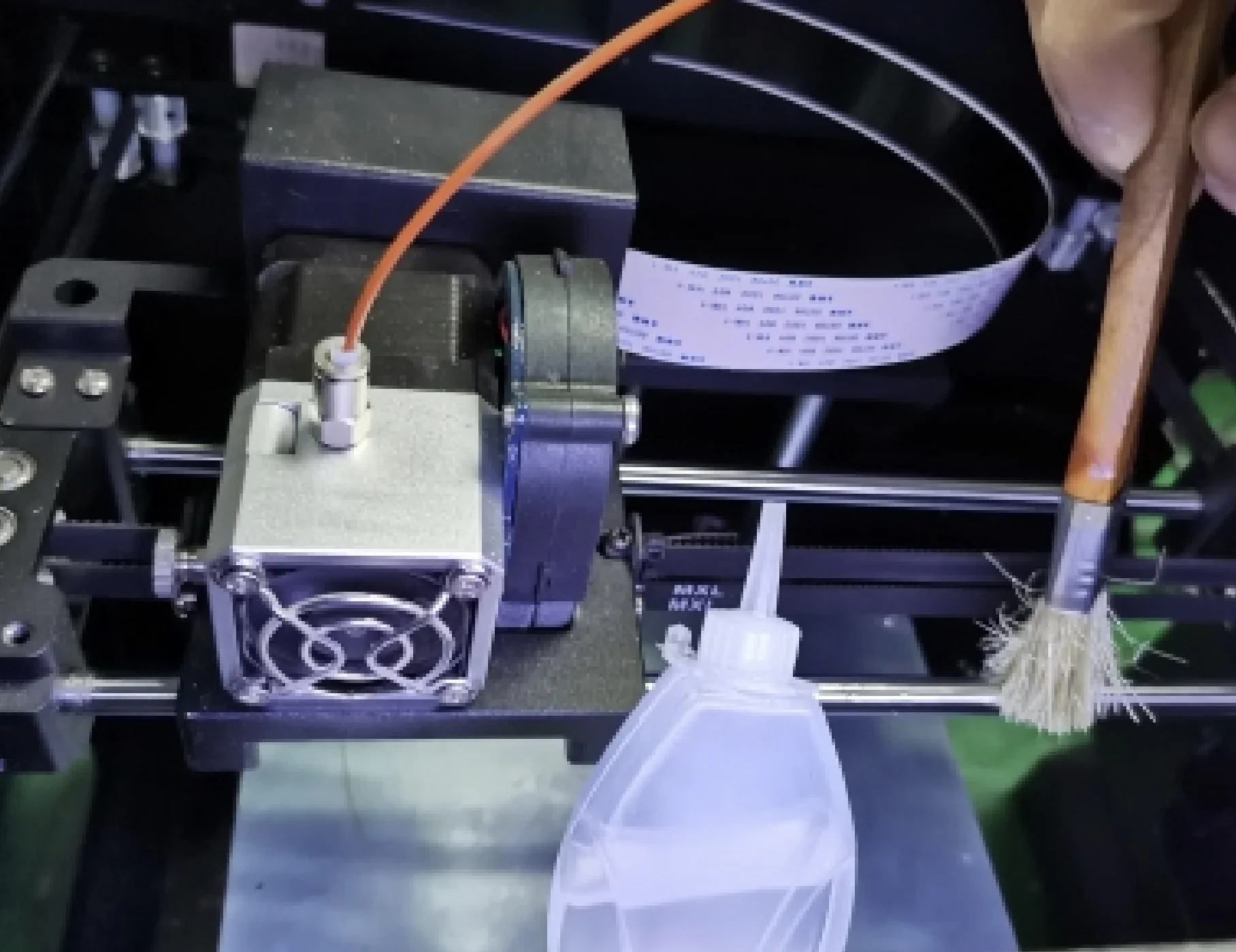 Creatbot F160 3D printer interior, featuring a brush cleaning extruder components; visible wiring and cooling fan, showcasing maintenance process.