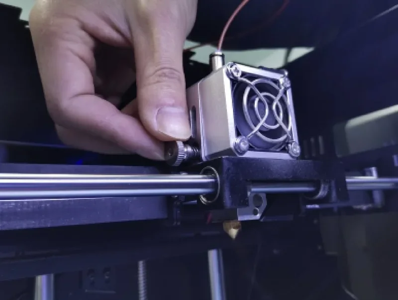 Hand adjusting the Creatbot F160 3D printer extruder fan, highlighting the printer's technical components and build quality.