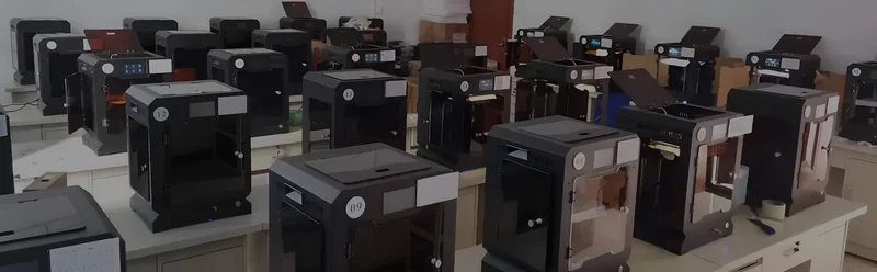 Creatbot F160 3D printers line a room, showcasing multiple black units with transparent doors on workbenches.