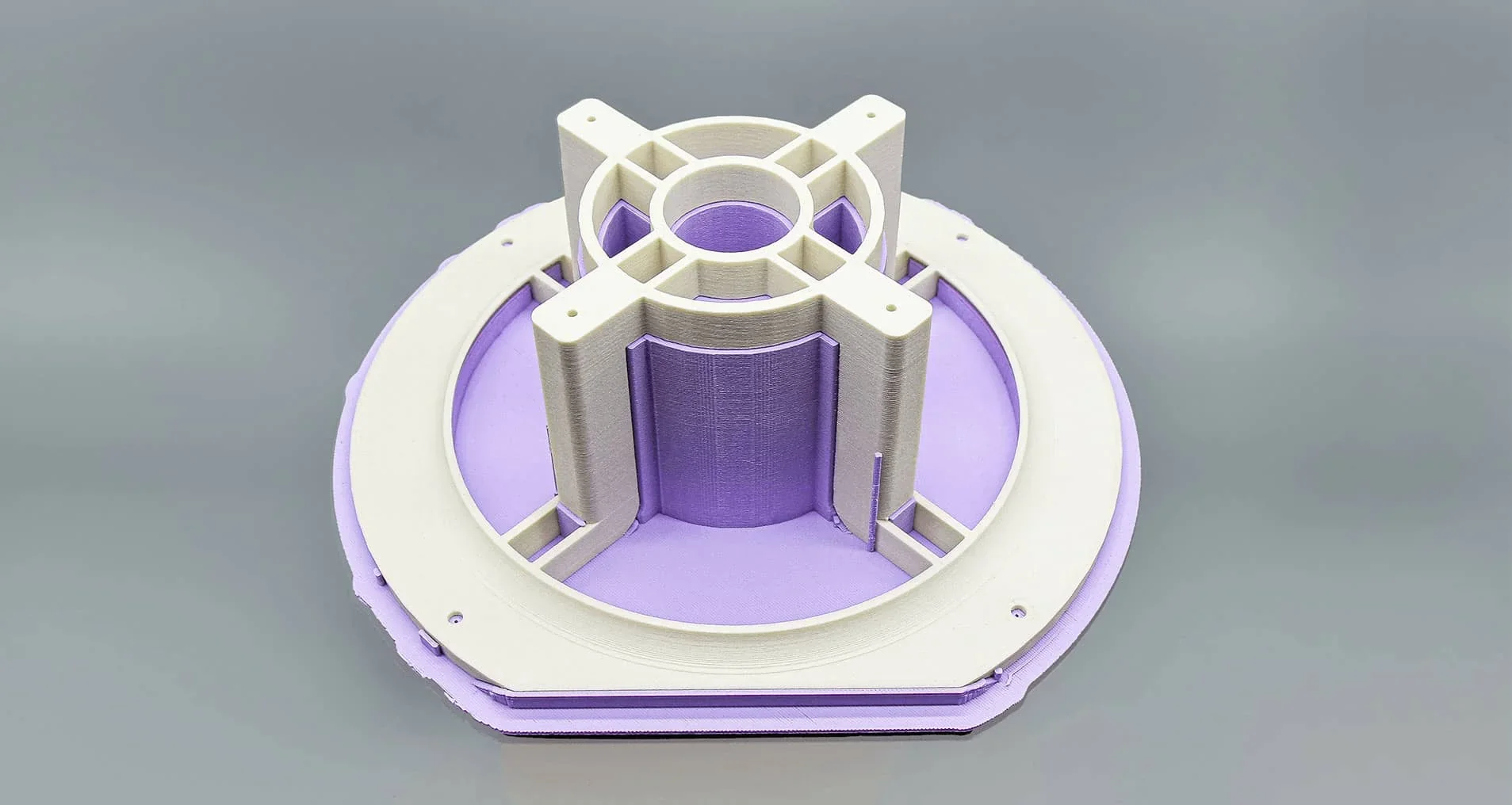 3D-printed white and purple model part created by Creatbot F430, featuring a circular base with geometric structures, against a gray background.