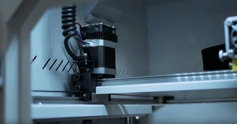 CreatBot F430 3D printer interior, showing motor and mechanical parts in a sleek, industrial setting, exemplifying precision engineering.