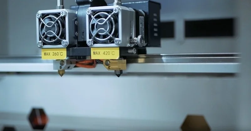 Creatbot F430 3D printer close-up showing dual extruders with temperature labels, set in a well-lit environment showcasing precision engineering.