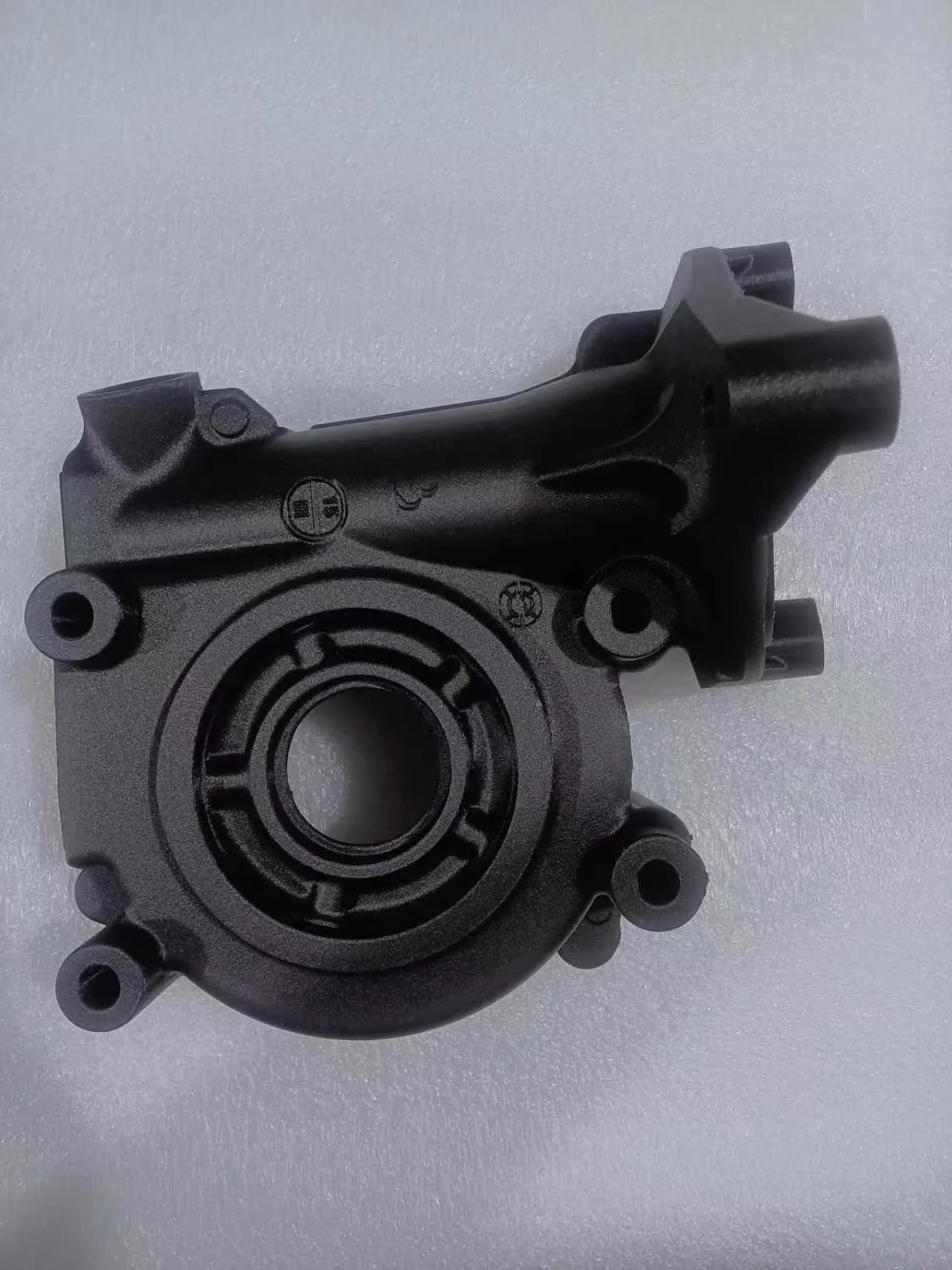 Black mechanical part made by CreatBot F430 NX 3D printer on a textured white background, showcasing precision and detail.