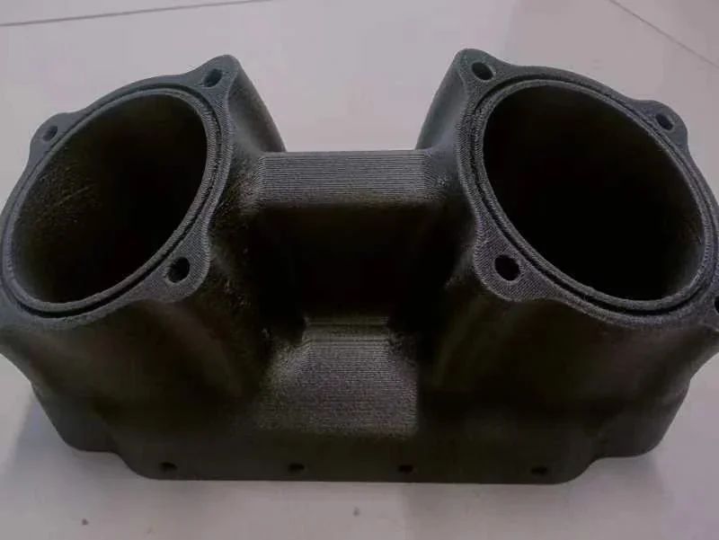 Black 3D-printed dual-chamber part on flat surface, created by Creatbot F430 NX, showing precision engineering and smooth surface texture.