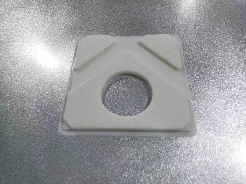 White 3D printed part with center hole on metallic surface, created by creatbot f430 nx.