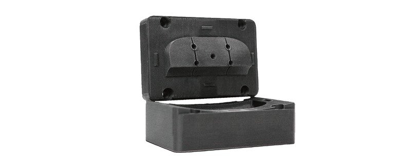A black PEEK mold box with a lid slightly open, showcasing its sturdy and compact design. It is a sample output created by the Creatbot PEEK-250 3D printer, demonstrating the printer's capability to produce high-quality, precise components using PEEK material.