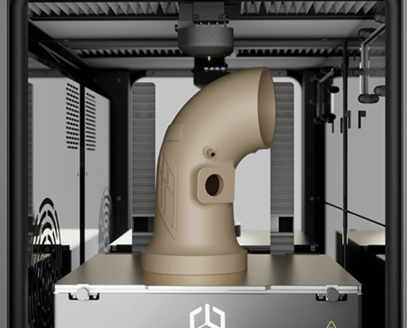 A tan, elbow-shaped pipe model inside the CreatBot PEEK-250 3D printer emphasizes its ability to produce complex, industrial-grade components. The printer's internal structure includes ventilation and control mechanisms, reflecting its high-performance and advanced engineering capabilities.