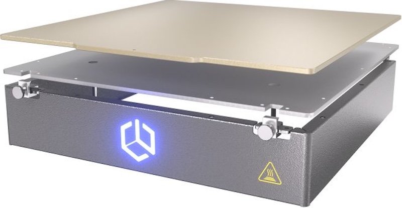 The image showcases a component of the Creatbot PEEK-250 3D printer, specifically the heated build platform. The platform features a dark metallic base with a faintly textured finish, a prominent LED-lit logo on the front, and an exclamation mark inside a triangular warning symbol indicating heat caution. On top of the base, there are multiple layers, including a transparent middle layer and a cream-colored top build plate. The platform is designed for high-temperature printing, suitable for materials like PEEK. The setting is minimal, focusing on the product's technical aspects without any branding distractions.