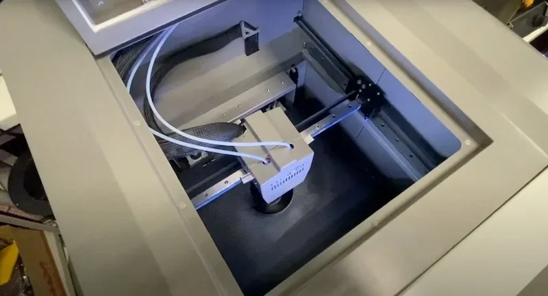 CreatBot PEEK-300 3D printer interior showing print bed and mechanisms, with cables, in an industrial setting.