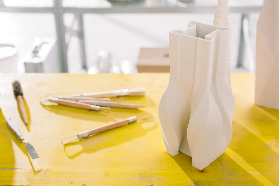 Delta WASP 2040 Clay print on yellow table with clay-sculpting tools, showcasing intricate design and craftsmanship.