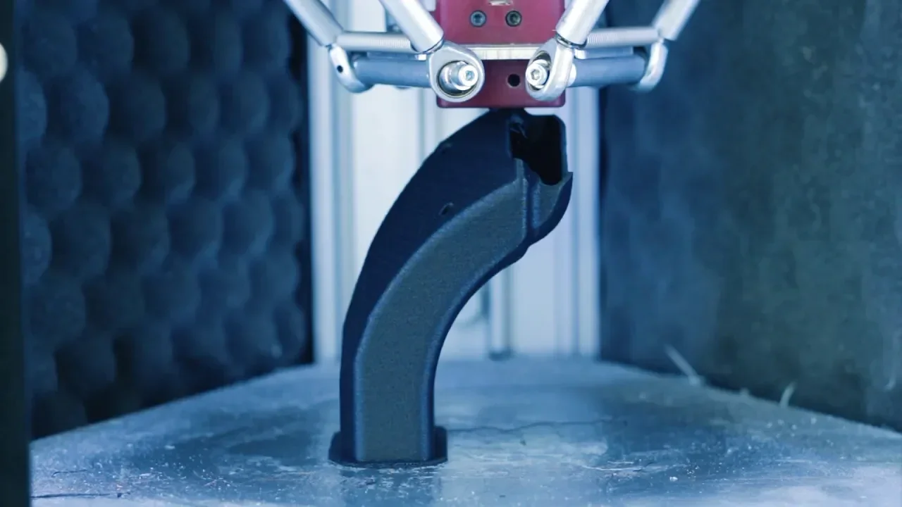 Delta Wasp 2040 Industrial X printing a curved black part, showcasing precise 3D printing in a technical setting.