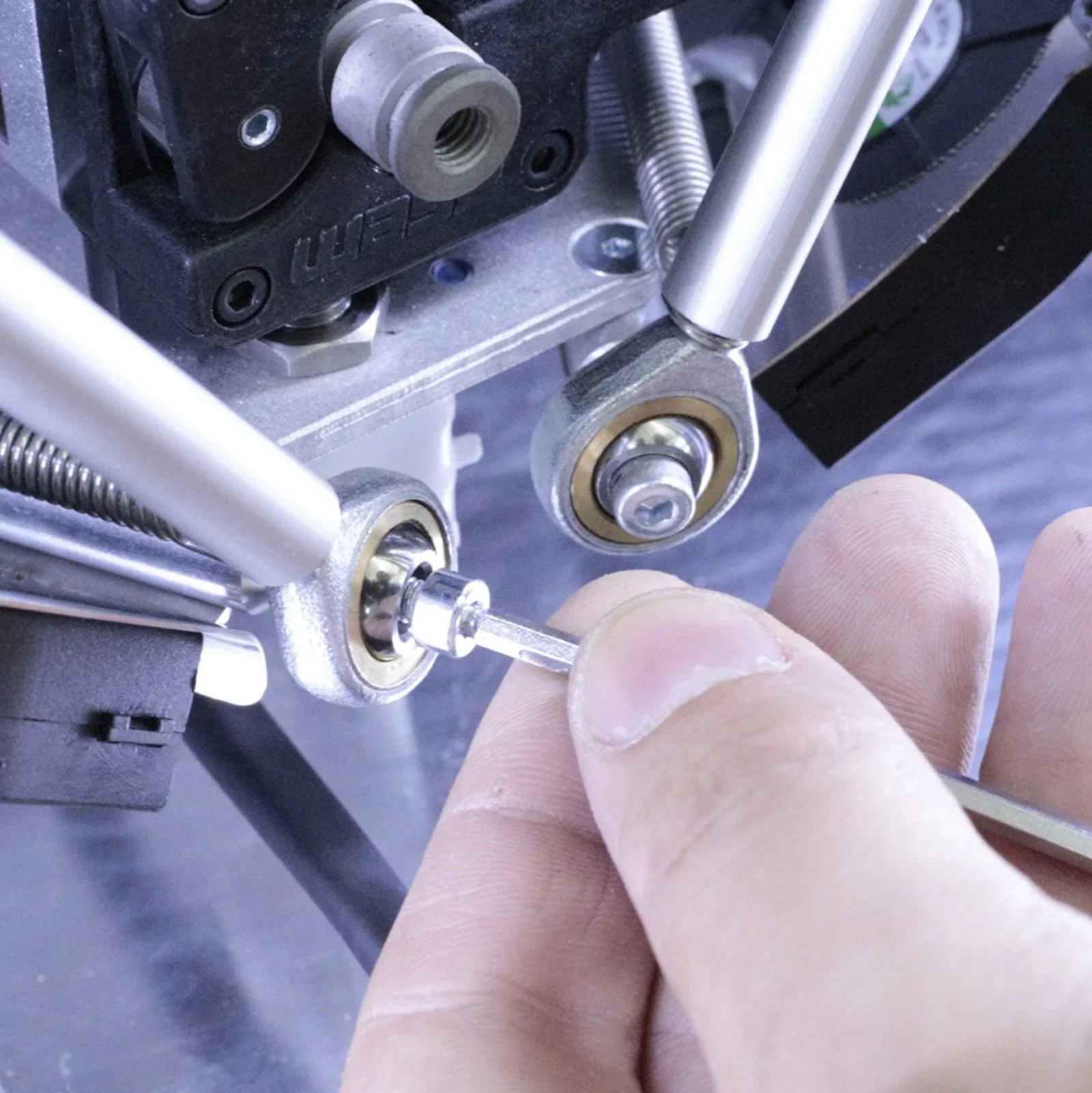 Close-up of Delta WASP 2040 Industrial X 3D printer's mechanical components with a hand adjusting a tool, showcasing precision engineering.