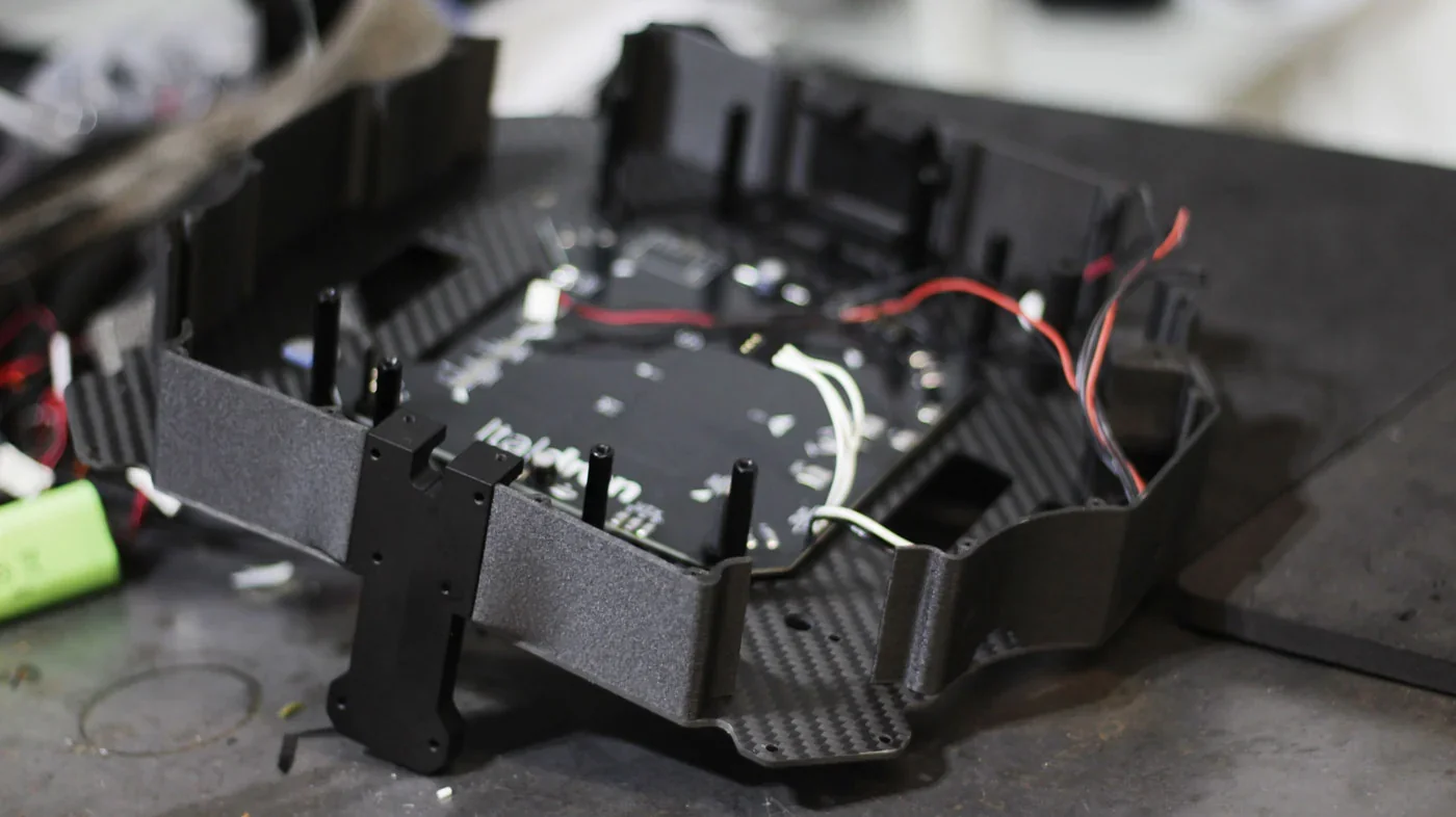3D-printed component with wires and black casing created by Delta WASP 2040 Industrial X, resting on a workbench.
