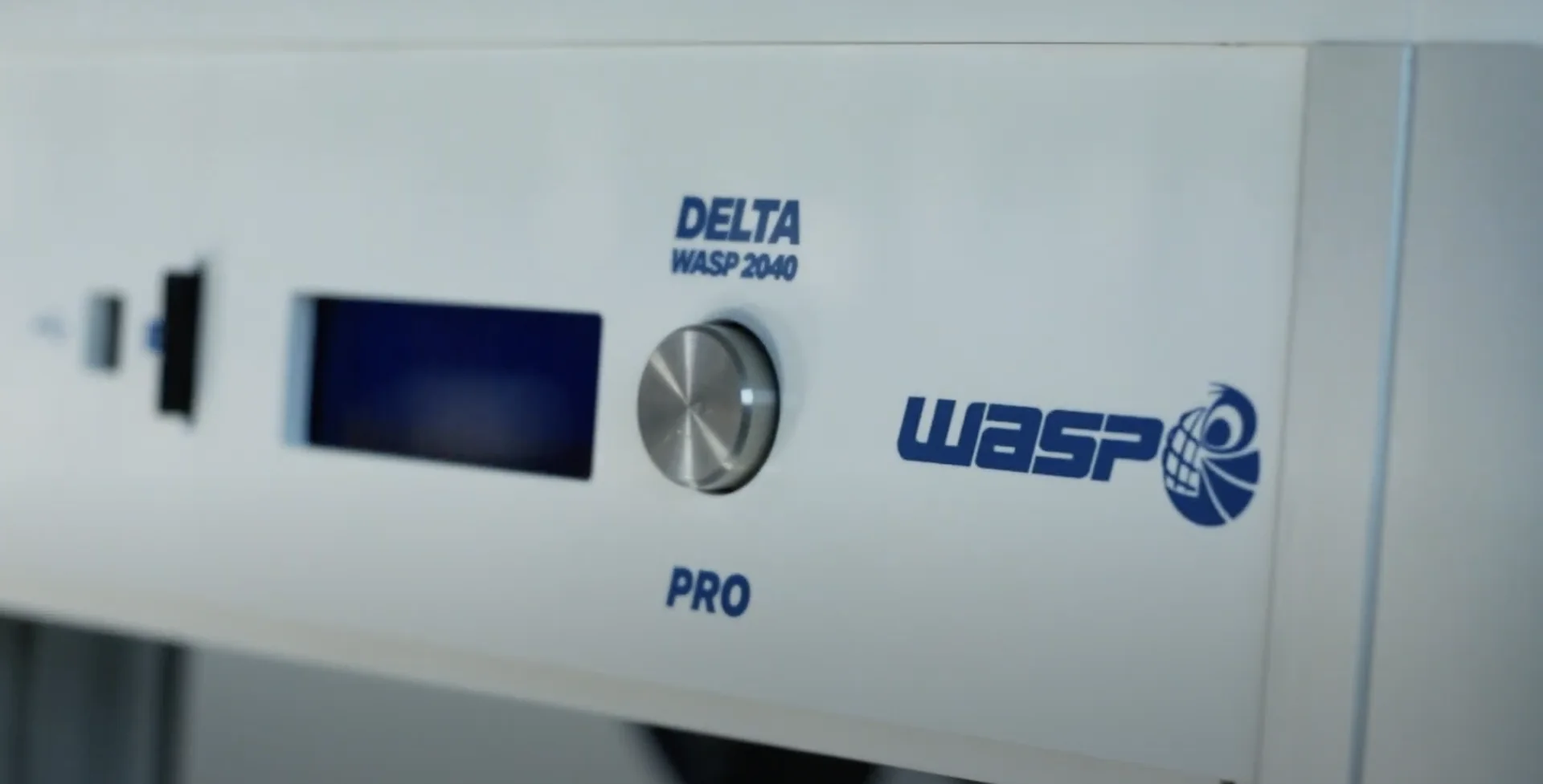Delta WASP 2040 Pro 3D printer close-up showing control knob, display, and branding on the front panel, emphasizing design and functionality.