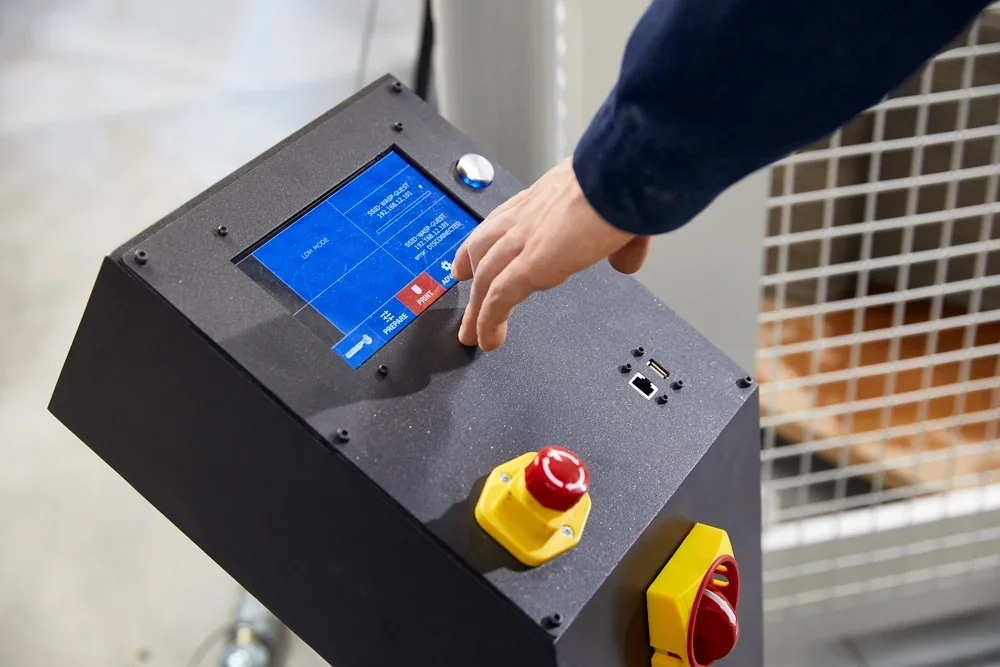 Control panel for Delta Wasp 3MT 3D printer with touch screen and emergency stop button. Hand operating interface.