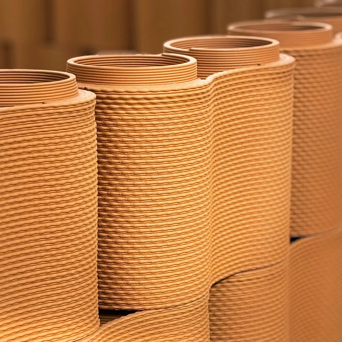 Clay vases with textured patterns, created by the Delta Wasp 40100 Clay 3D printer. The image showcases precision and artistic design.