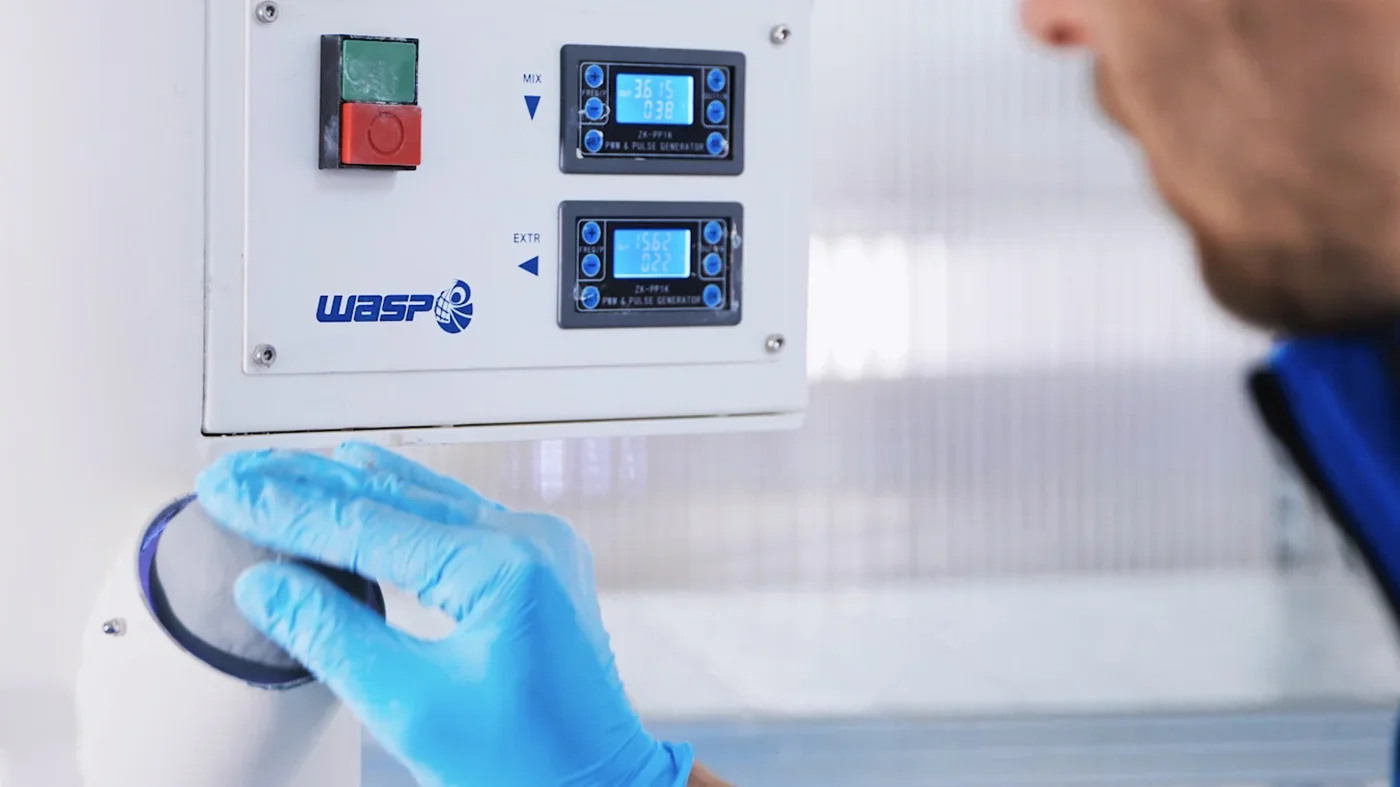 Delta WASP 40100 Clay control panel with branded logo, digital displays, and gloved hand adjusting clay output against a light background.