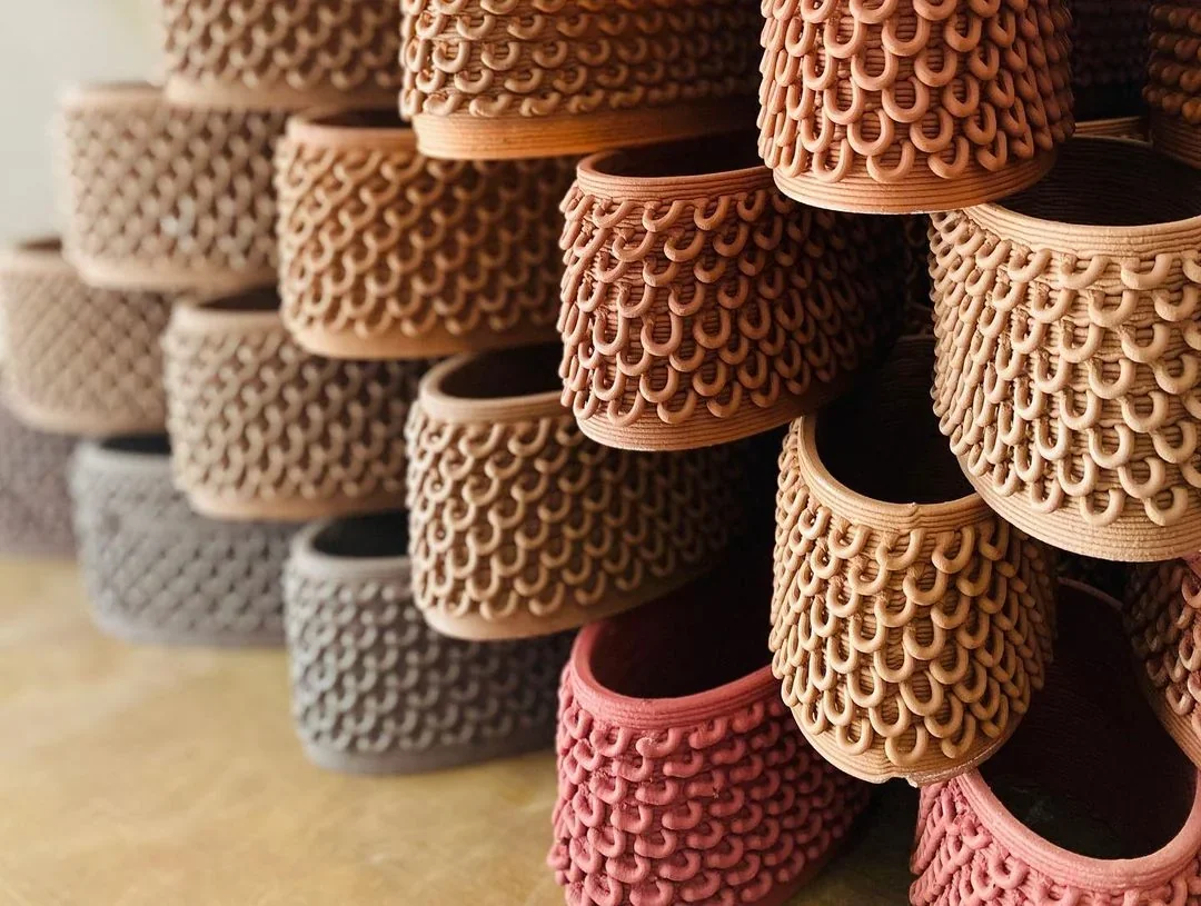 Clay pots with intricate patterns, 3D printed by delta wasp 40100 clay, stacked on a surface, showcasing texture and design variations.