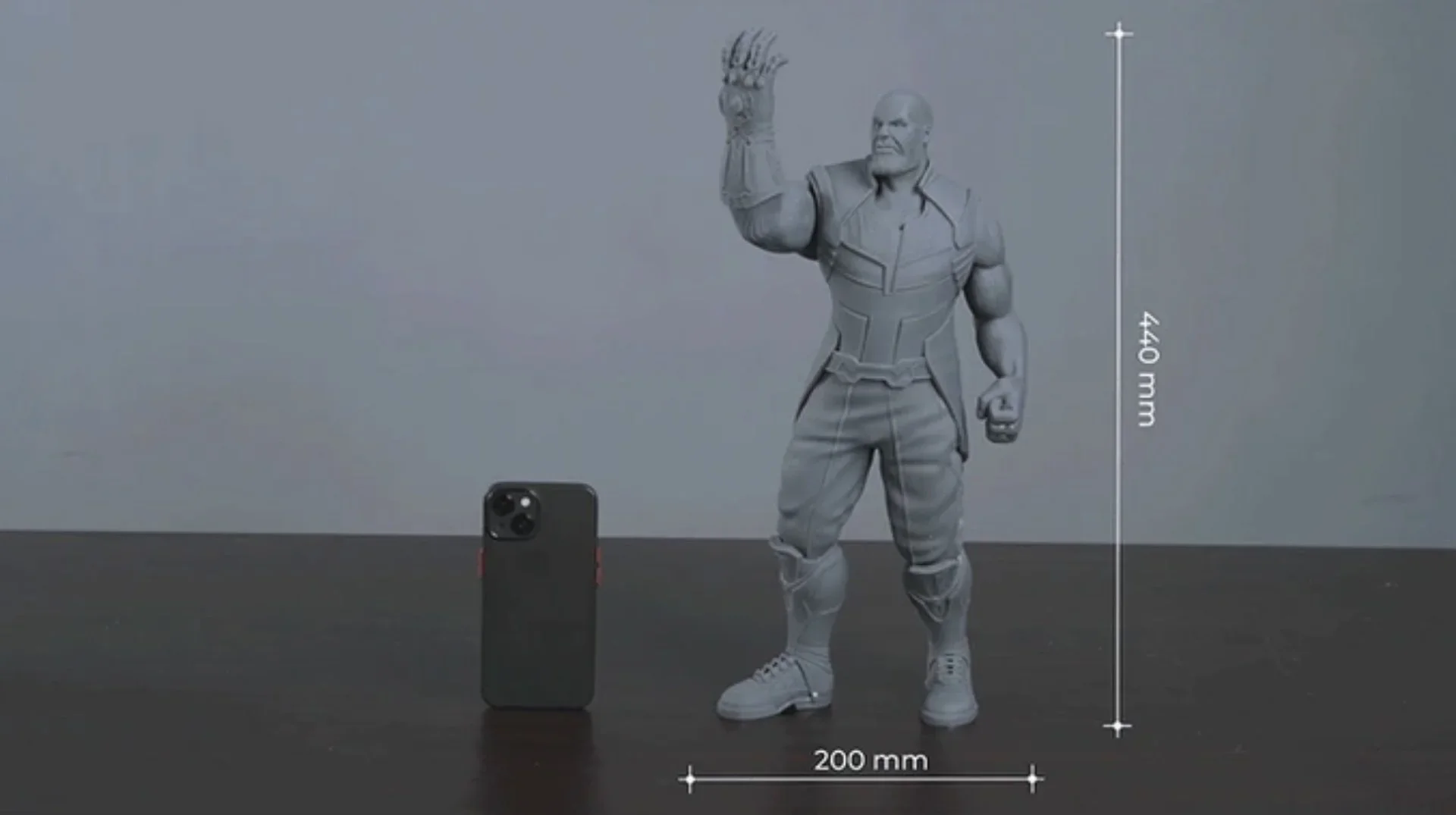 emake3d galaxy 1 3D printed figure of a muscular character, 440 mm tall, beside a smartphone for scale, on a dark surface with measurements.