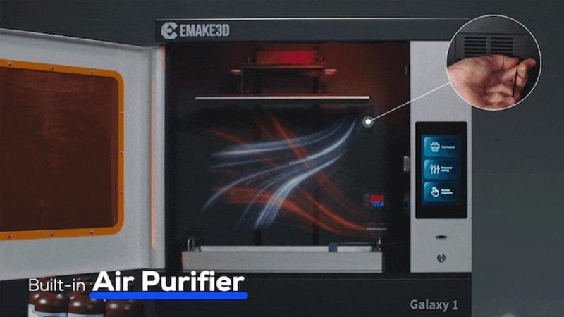 The image features the Emake3D Galaxy 1 3D printer, showcasing its integrated air purifier system. The printer has a sleek, modern design with a dark-colored exterior and a transparent front panel for easy viewing of the printing chamber. The branding "EMAKE3D" and "Galaxy 1" are prominently displayed on the machine. A digital touchscreen interface is located on the right side, providing user-friendly controls and information. The illustration within the image highlights the airflow, demonstrating the built-in air purifier functionality. This is further emphasized with detailed graphics indicating the purification process, enhancing the operational environment by filtering out particulates. The setting is within a workshop or studio environment, implying its professional-grade usage. The image emphasizes the technical and innovative features of the 3D printer, making it suitable for SEO and accessibility by detailing its functionality and design.