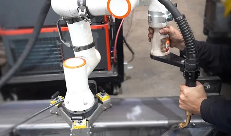 Robot arm fairino fr16 performing welding with precision on metal, featuring a white and orange design, demonstrating industrial automation.
