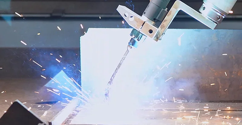 Robotic arm fairino fr16 welding metal, with bright sparks and blue light in an industrial setting.