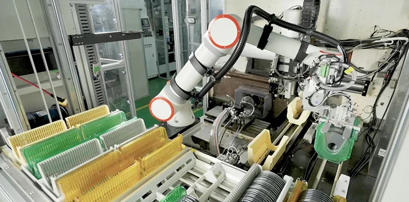 fairino fr16 robot in factory assembling parts, surrounded by circuit boards, wires, and machinery; industrial automation setup in progress.