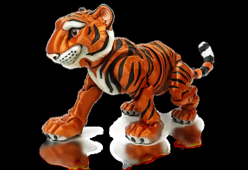 A detailed and vibrantly colored 3D-printed model of a tiger, created by the Flashforge Adventurer 5X 3D printer. The model showcases intricate design work, with striking orange and black stripes typical of a tiger's fur pattern, white accents on the face and underbelly, and defined facial features including expressive eyes. The tiger is depicted in a dynamic, walking pose. The clarity and smooth finish of the model highlight the printer's capability for high-resolution and multi-color outputs. The scene focuses solely on the model, emphasizing its realistic and high-quality construction, indicative of the printer's advanced technology and precision.