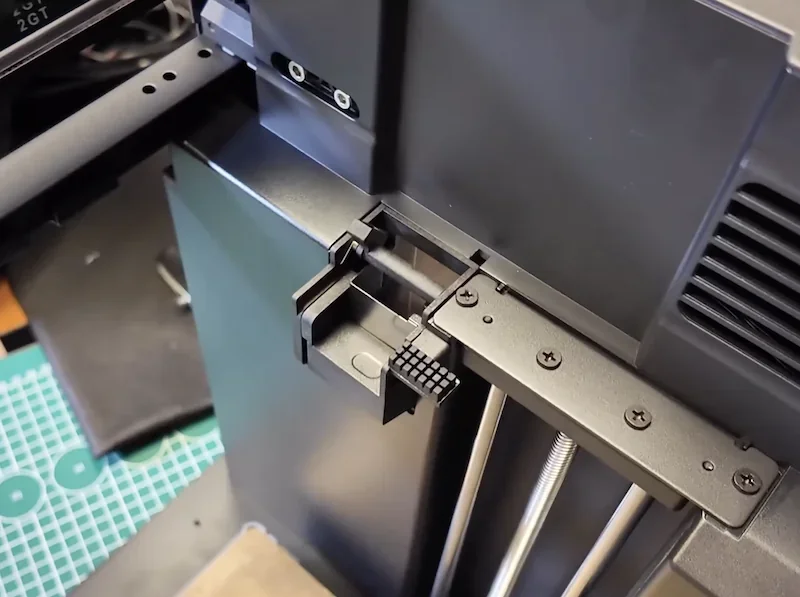 Flashforge AD5X 3D printer with black casing, detailed view of mechanical parts and printed sample object on a workbench.