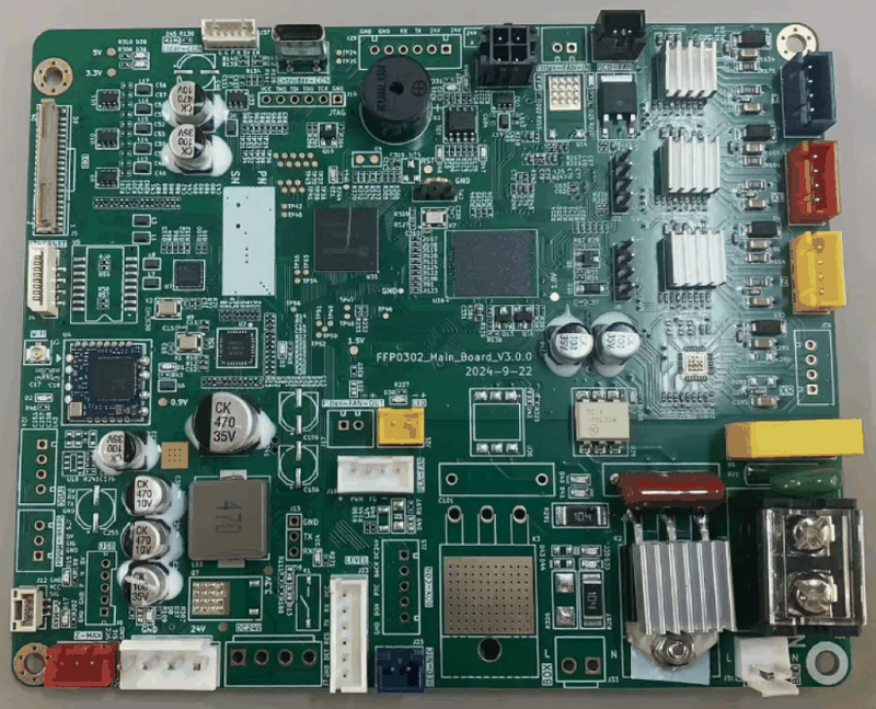 A detailed view of a 3D printer main board, possibly for the Flashforge AD5X. The circuit board is densely packed with components, featuring multiple capacitors marked with values like "CK 470 35V" and "CK 10V." Integrated circuits of various sizes are centrally positioned, surrounded by connectors and headers for interfacing with other machine parts. There are heat sinks visible on the board, suggesting areas that manage thermal regulation. The PCB is labeled "FPP032_Main_Board_v3.0.0" with a date code of "2024-9-22." The layout includes various power connectors and interface ports, including color-coded terminal blocks and molex connectors, likely used for stepper motor connections and other peripheral components essential for 3D printer operation. The board color is a standard green, with white silkscreen markings detailing the board’s circuitry paths and components placement.