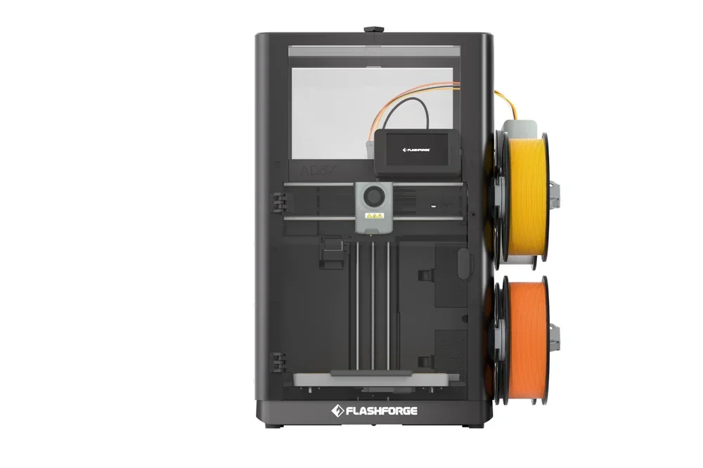 Flashforge AD5X 3D printer with dual filament spools on the side, enclosed build chamber, and visible branding.