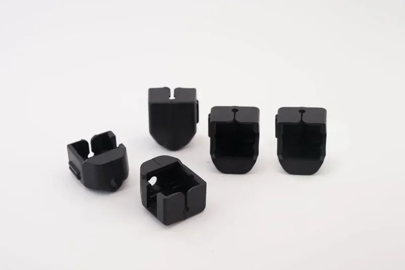 Black 3D printed parts created by the Flashforge AD5X, showcased on a white background.