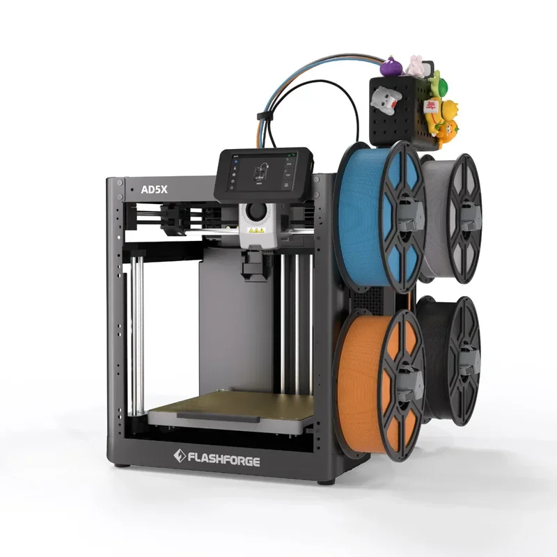 The image displays a Flashforge AD5X 3D printer with a robust, open-frame design. Prominently featuring a high-definition touchscreen interface mounted centrally on the top frame, the printer allows for intuitive operation. The print head is positioned within the spacious build area, highlighting its capability for large-scale projects. To the right, a vertically mounted spool holder accommodates four filament spools in assorted colors, including blue, gray, orange, and black, indicating versatility in material use. The brand name "Flashforge" appears at the base of the machine, reinforcing brand identity. Above the spools, colorful figurines adorn the top, adding a playful touch to the industrial aesthetic. The machine’s sleek metal frame, combined with its advanced technical features, showcases its sophisticated engineering designed for precision and reliability in 3D printing tasks.
