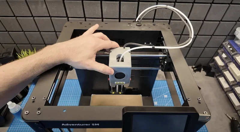Flashforge Adventurer 5M 3D printer in operation, showcasing a user accessing the print head.