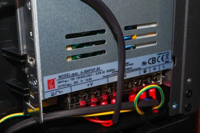 Flashforge Adventurer 5M internal power supply with model details, wiring, and vents visible.