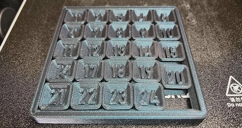 Flashforge Adventurer 5M Pro 3D printed numbered puzzle, arranged in a 5x5 grid with raised digits, showcasing the printer's precision.