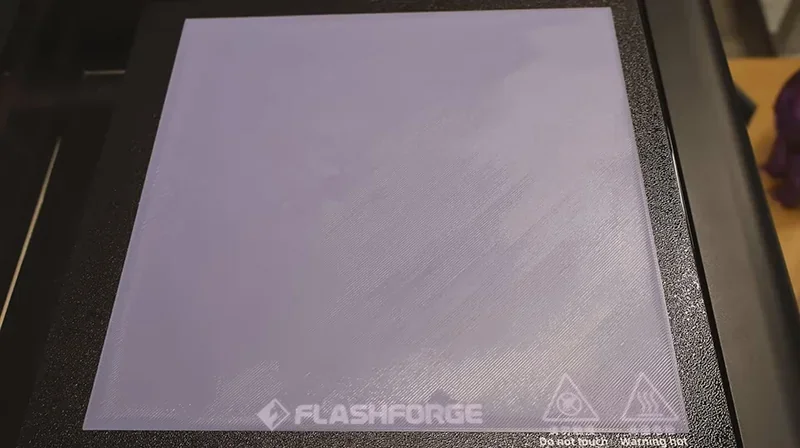 Flashforge Adventurer 5M Pro 3D printer platform close-up, showing textured print surface and visible branding.